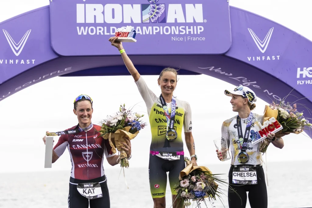 women celebrate at podium after finishing a triathlon