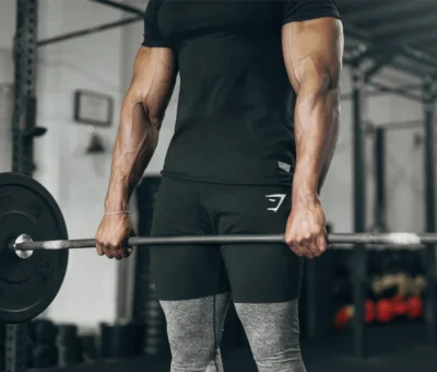 man lifts a barbell wearing Gymshark shorts