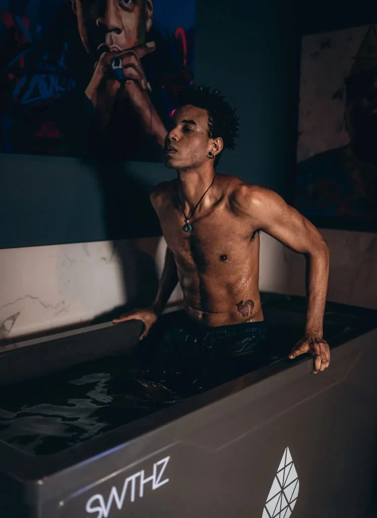 Young, black man getting into a cold plunge