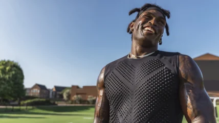 Black man wearing a weighted shirt to work out.