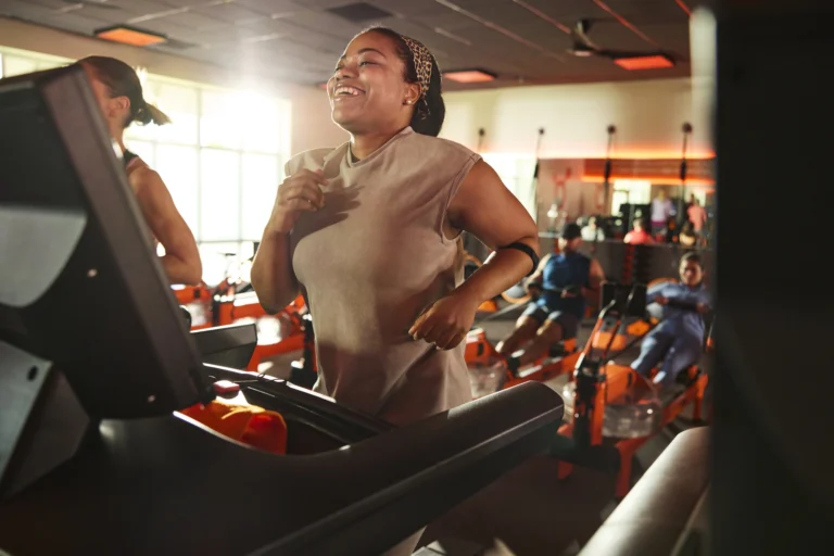 woman runs on a treadmill at an Orangetheory location