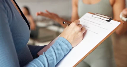 woman signs up for a membership using a clipboard